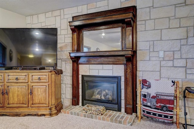 living area with carpet floors, a large fireplace, and a textured ceiling