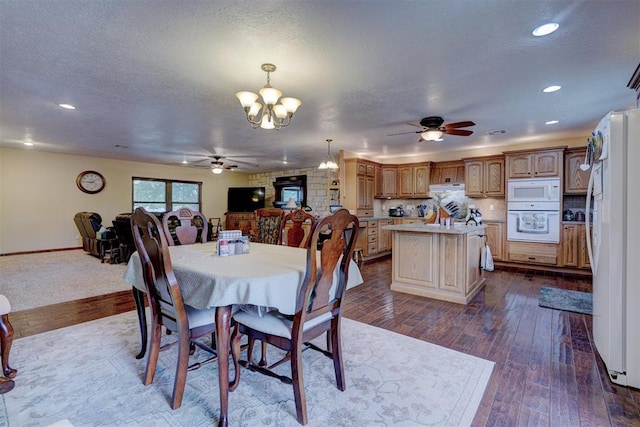 dining space with dark wood-style floors, recessed lighting, a textured ceiling, baseboards, and ceiling fan with notable chandelier