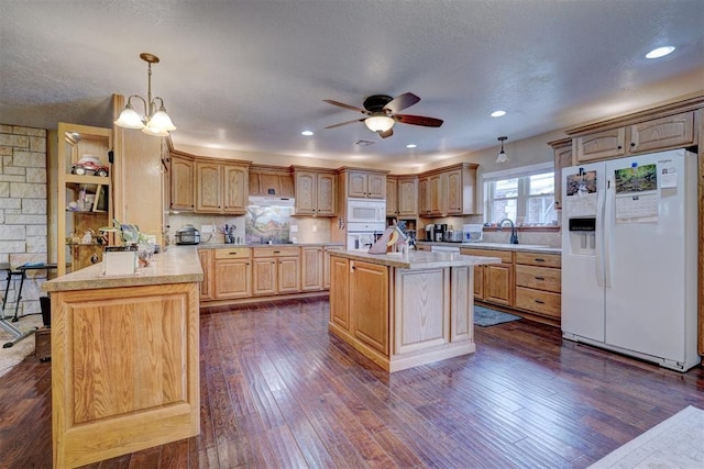 kitchen with white appliances, light countertops, a peninsula, and dark wood-style flooring