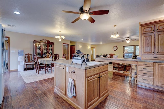 kitchen featuring dark wood-style floors, decorative light fixtures, light countertops, a textured ceiling, and a sink