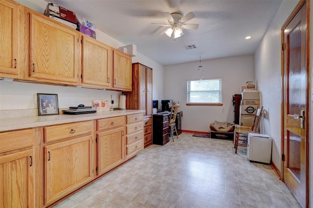 kitchen featuring visible vents, baseboards, ceiling fan, light countertops, and light brown cabinets