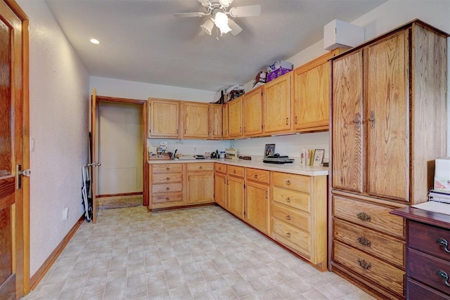 kitchen featuring light floors, ceiling fan, baseboards, and light countertops