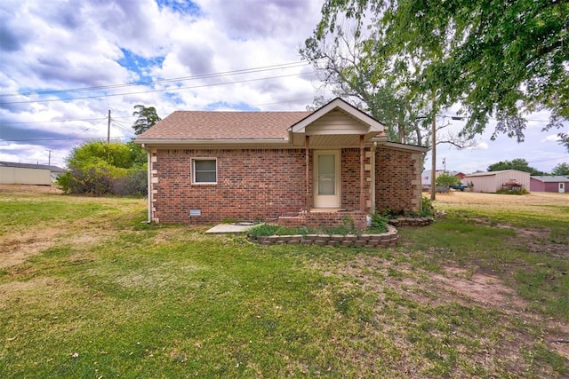 ranch-style home featuring crawl space, brick siding, a front lawn, and roof with shingles