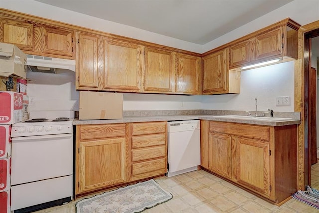 kitchen with under cabinet range hood, white appliances, a sink, light countertops, and light floors