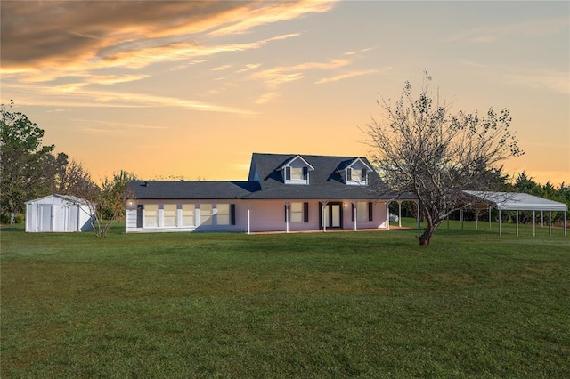 view of front of property with an outdoor structure, a lawn, and a storage shed