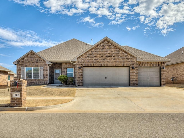 view of front of property featuring a garage, concrete driveway, brick siding, and roof with shingles