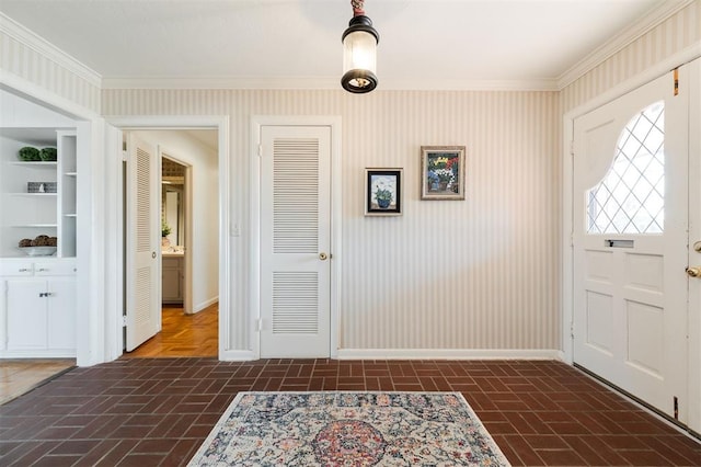 entrance foyer featuring brick patterned floor, crown molding, and baseboards