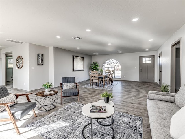 living room with visible vents, wood finished floors, and recessed lighting