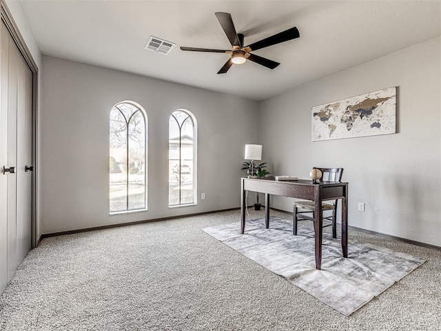 home office with ceiling fan, carpet flooring, visible vents, and baseboards