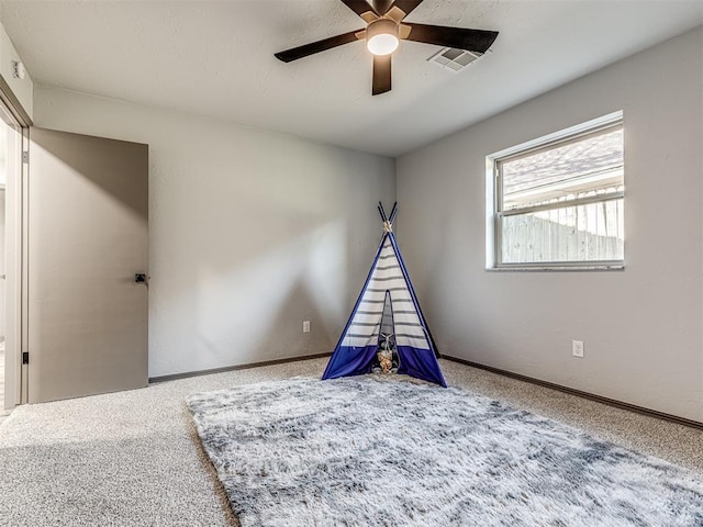 recreation room with ceiling fan, carpet floors, visible vents, and baseboards