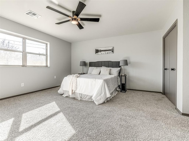 carpeted bedroom featuring ceiling fan, visible vents, and baseboards