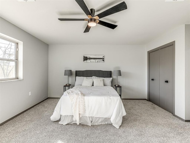 bedroom with ceiling fan, a closet, carpet flooring, and baseboards