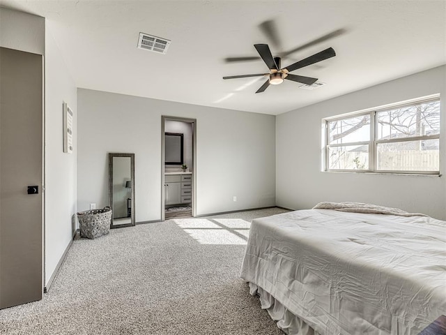 carpeted bedroom with a ceiling fan, visible vents, ensuite bath, and baseboards