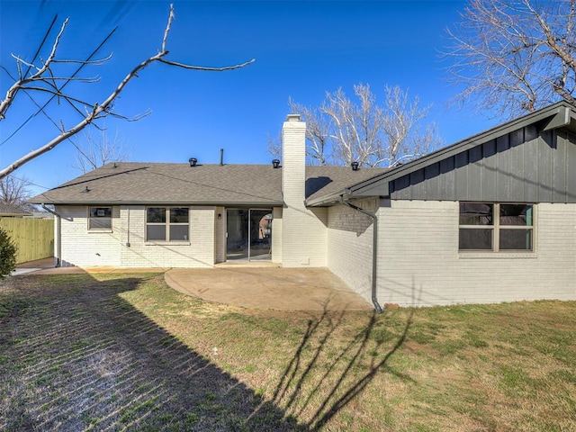 back of property featuring a patio, a chimney, fence, a yard, and brick siding