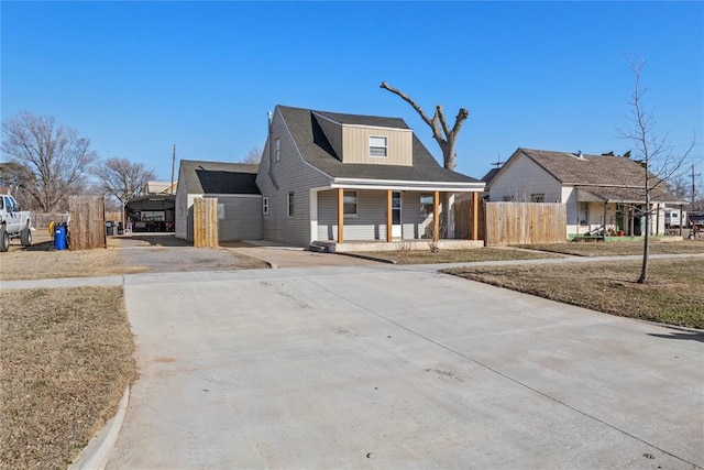 bungalow-style home with covered porch and fence