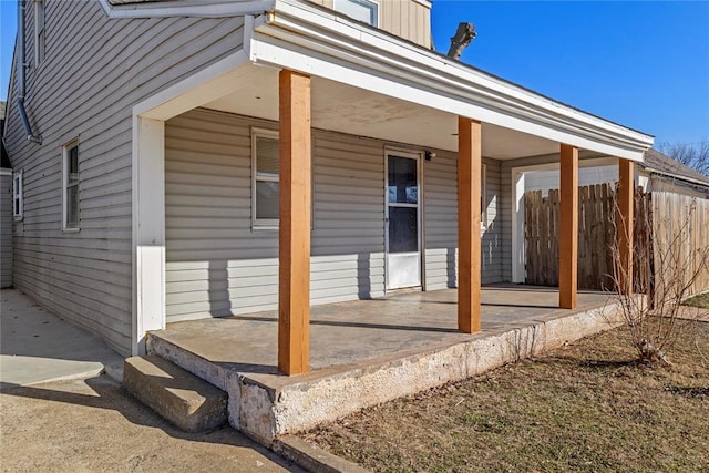 exterior space featuring a porch and fence