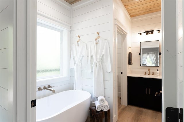 bathroom featuring wood ceiling, vanity, a freestanding tub, and a wealth of natural light