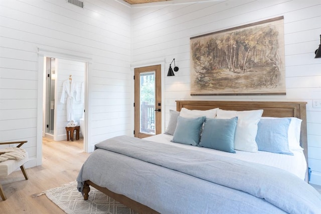 bedroom featuring wood finished floors and ensuite bathroom