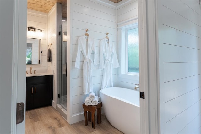 full bath with a freestanding bath, wood finished floors, a shower stall, and vanity