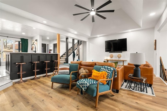 living room with a dry bar, light wood finished floors, a ceiling fan, stairway, and recessed lighting