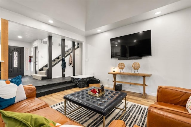 living area with stairs, wood finished floors, visible vents, and recessed lighting