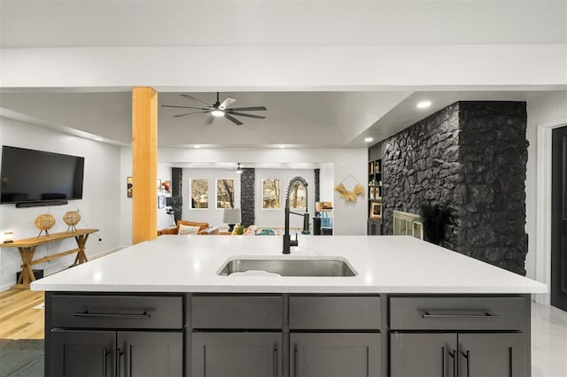 kitchen with gray cabinets, open floor plan, light countertops, and a sink