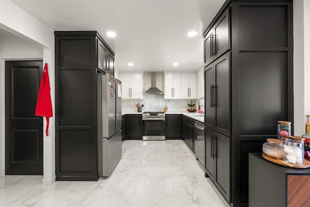 kitchen with decorative backsplash, appliances with stainless steel finishes, marble finish floor, wall chimney range hood, and recessed lighting