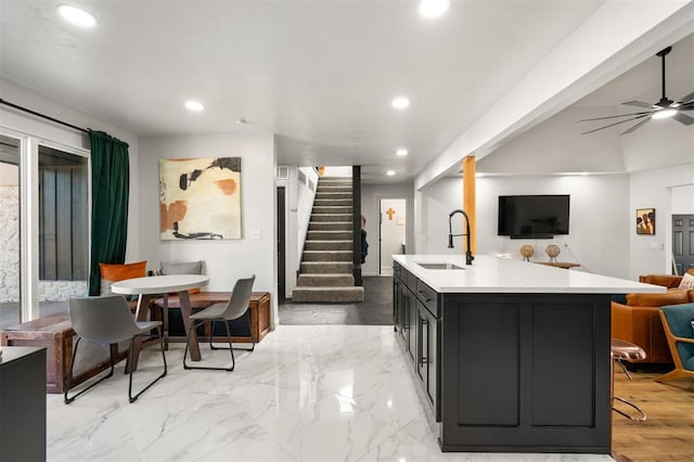 kitchen with a center island with sink, open floor plan, light countertops, a sink, and recessed lighting