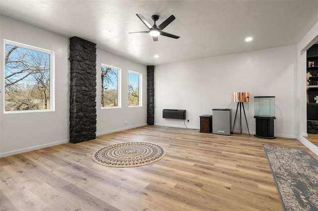 living area featuring baseboards, ceiling fan, wood finished floors, heating unit, and recessed lighting