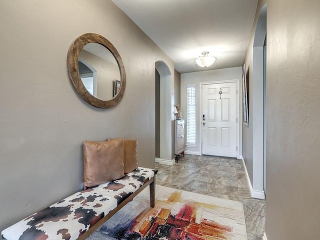 entrance foyer with arched walkways and baseboards