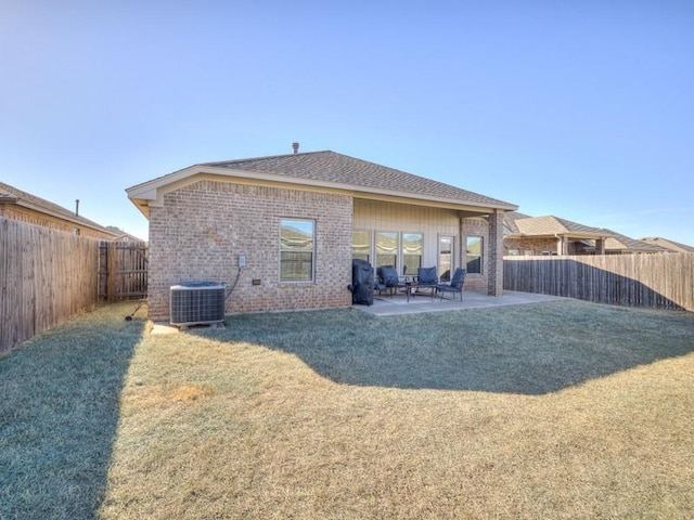 back of house with a patio, a fenced backyard, central air condition unit, brick siding, and a yard