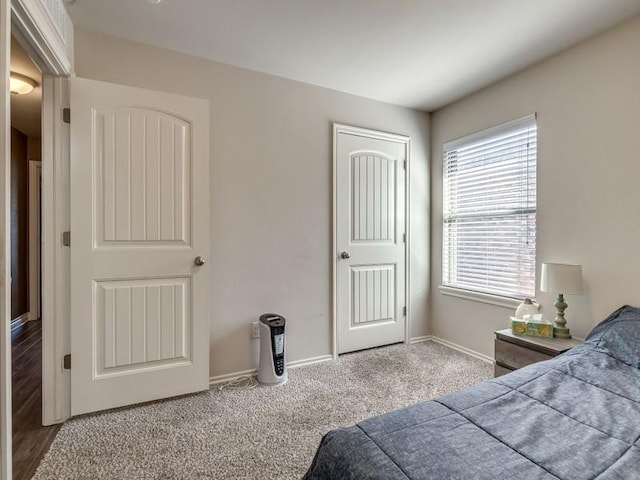 carpeted bedroom featuring baseboards and a closet