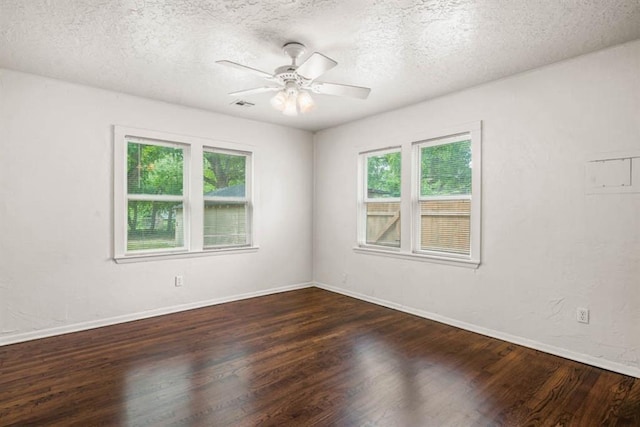 spare room with visible vents, a textured ceiling, wood finished floors, and a wealth of natural light