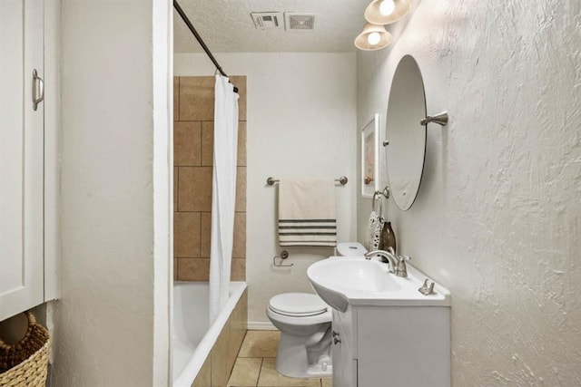 full bathroom featuring a textured wall, vanity, toilet, and tile patterned floors