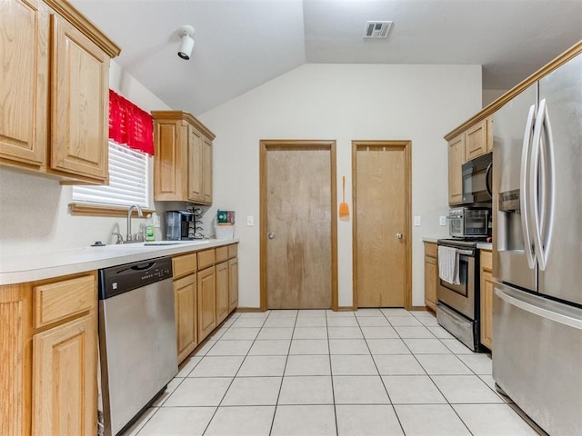 kitchen featuring visible vents, stainless steel appliances, light countertops, light brown cabinetry, and a sink