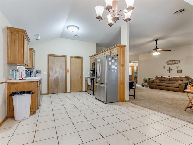 kitchen with stainless steel appliances, lofted ceiling, light countertops, visible vents, and light carpet