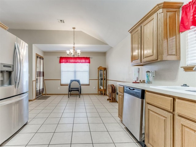 kitchen featuring stainless steel appliances, a sink, visible vents, vaulted ceiling, and light countertops