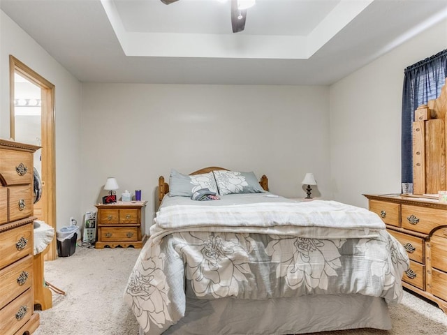 bedroom featuring carpet floors, ceiling fan, and a tray ceiling