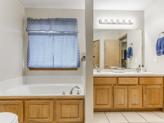 bathroom featuring a garden tub, double vanity, a sink, and tile patterned floors