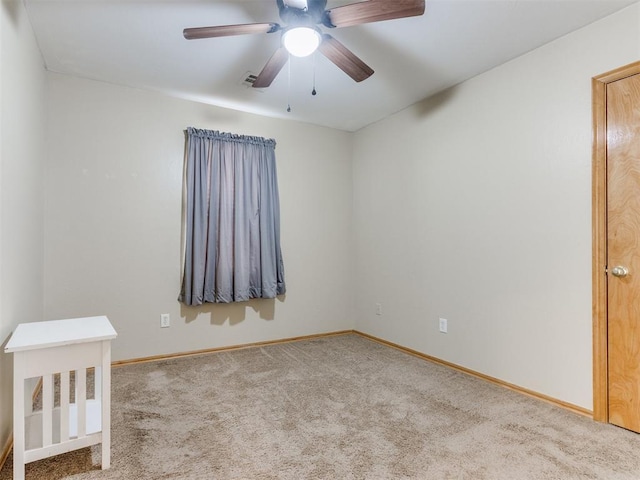 spare room with ceiling fan, carpet flooring, and baseboards