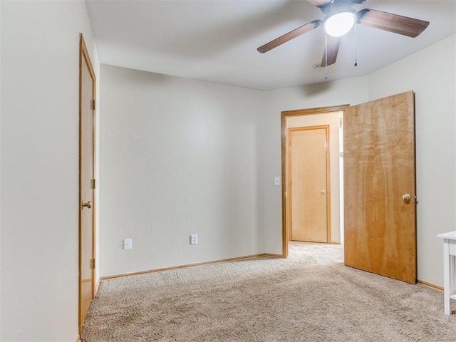 empty room with carpet floors, ceiling fan, and baseboards