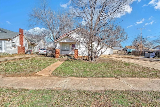 bungalow-style home with fence and a front lawn