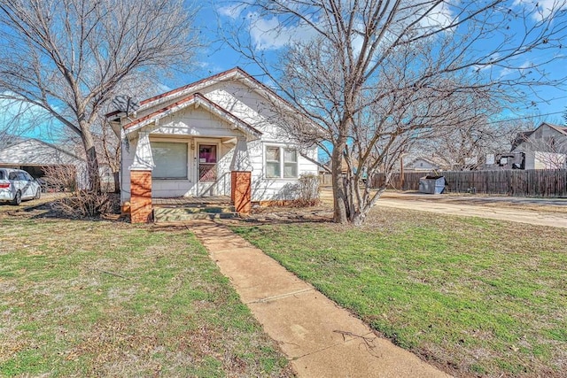 view of front of house featuring fence and a front lawn