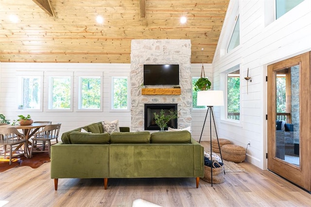 living room with high vaulted ceiling, wooden ceiling, wooden walls, a fireplace, and wood finished floors