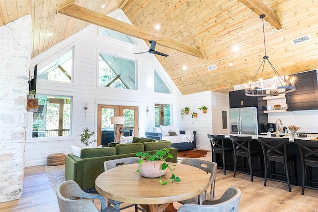 dining space featuring high vaulted ceiling, wooden ceiling, light wood-style flooring, ceiling fan with notable chandelier, and beam ceiling