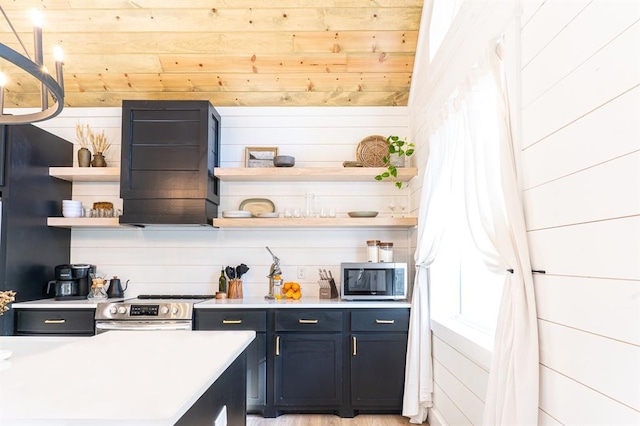 kitchen featuring stainless steel appliances, blue cabinetry, open shelves, and light countertops