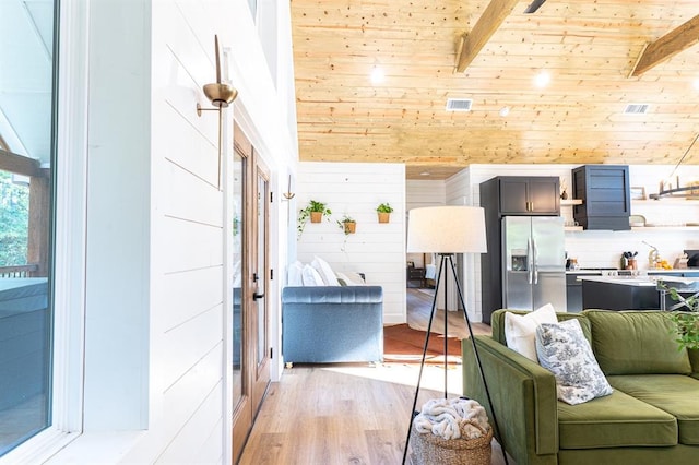 living room featuring wood ceiling, wood walls, light wood-style flooring, and lofted ceiling with beams