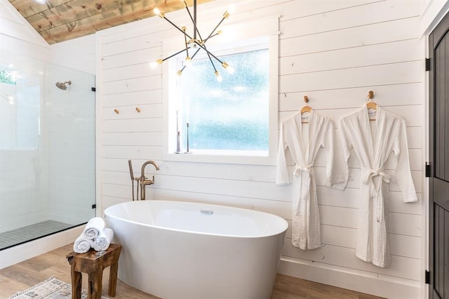 full bathroom featuring a stall shower, a freestanding tub, wood finished floors, and wood walls