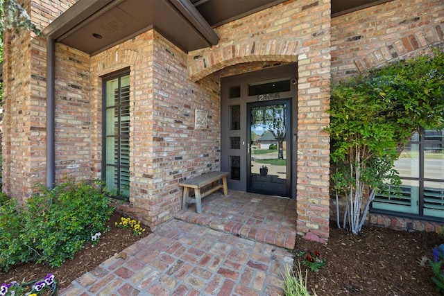 view of exterior entry with brick siding