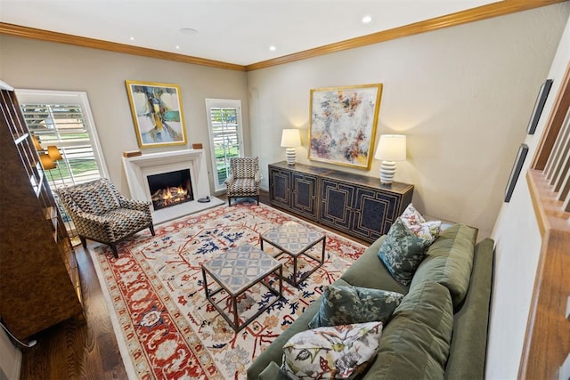 living room with crown molding, a lit fireplace, recessed lighting, and wood finished floors